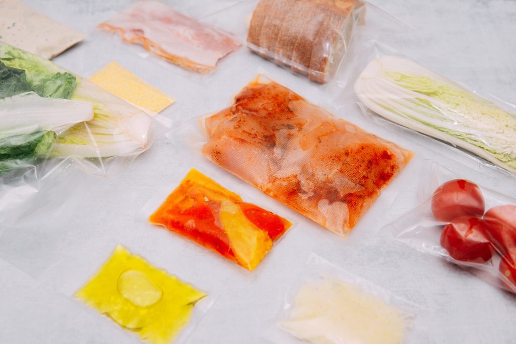 Vacuum‑sealed bags filled with assorted fresh ingredients arranged on a countertop.